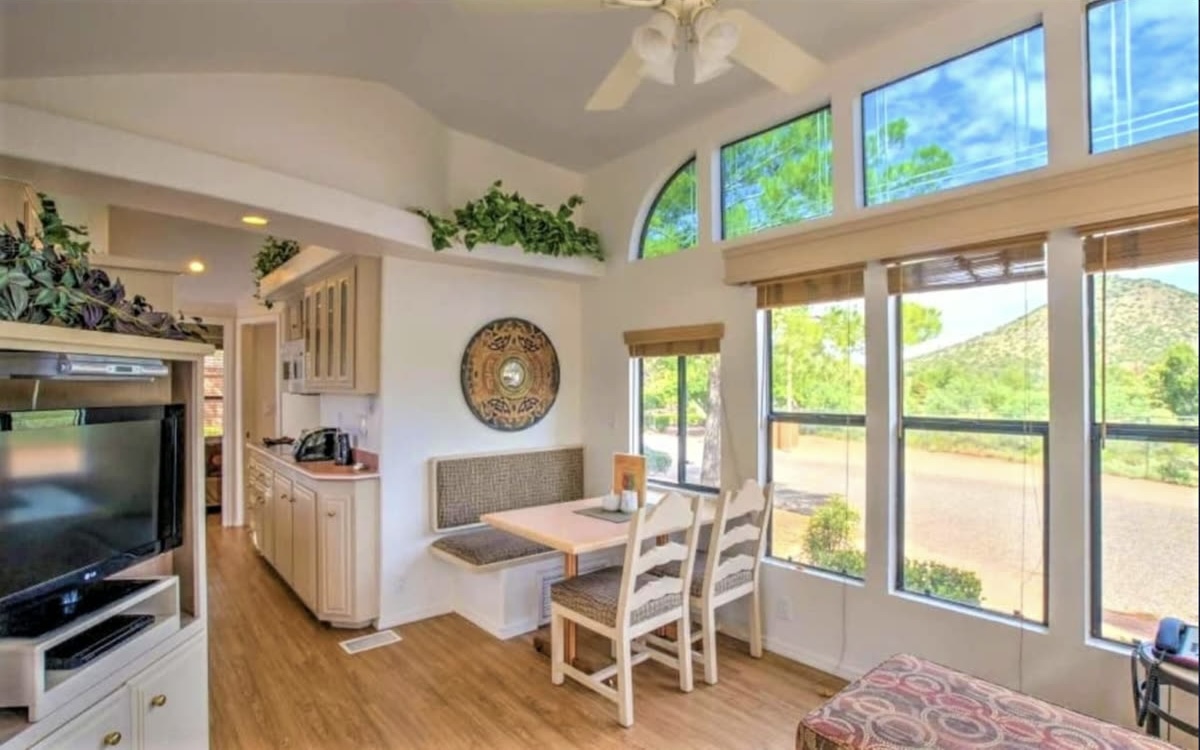 Inside a Sedona Pines cottage: kitchen, dining nook and a wall of windows looking out to the hills